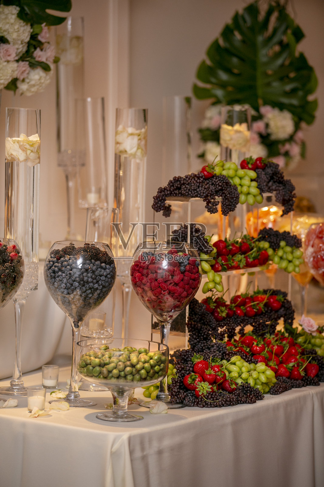 室内婚礼自助餐，一桌不同的水果，浆果，葡萄，草莓和蓝莓照片摄影图片