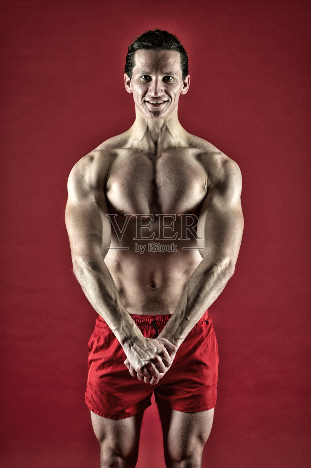 肌肉发达的男子运动员自信地站着。有吸引力的家伙，肌肉发达的胸部。骄傲卓越的身材。肌肉健美运动员的概念。健康和强壮。肌肉发达的帅哥。提高自己照片摄影图片