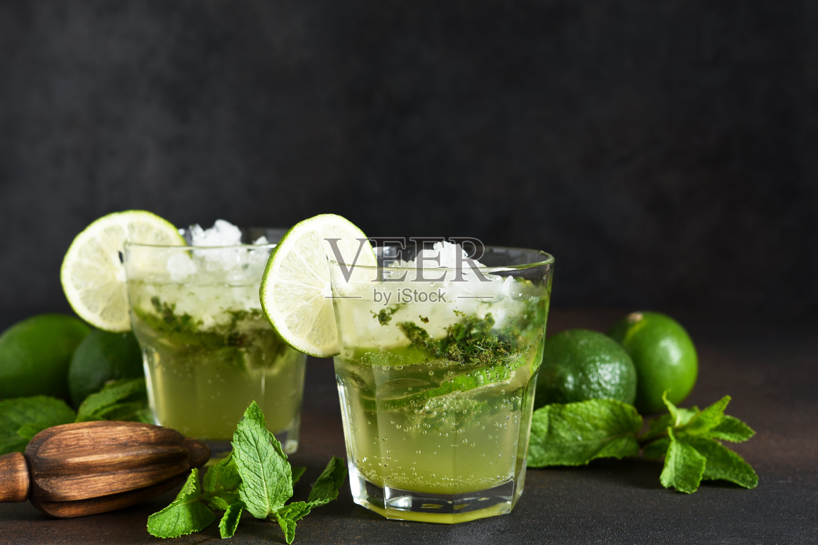 夏季鸡尾酒。经典的夏季饮料-莫吉托在一个玻璃杯在一个黑暗的背景。照片摄影图片