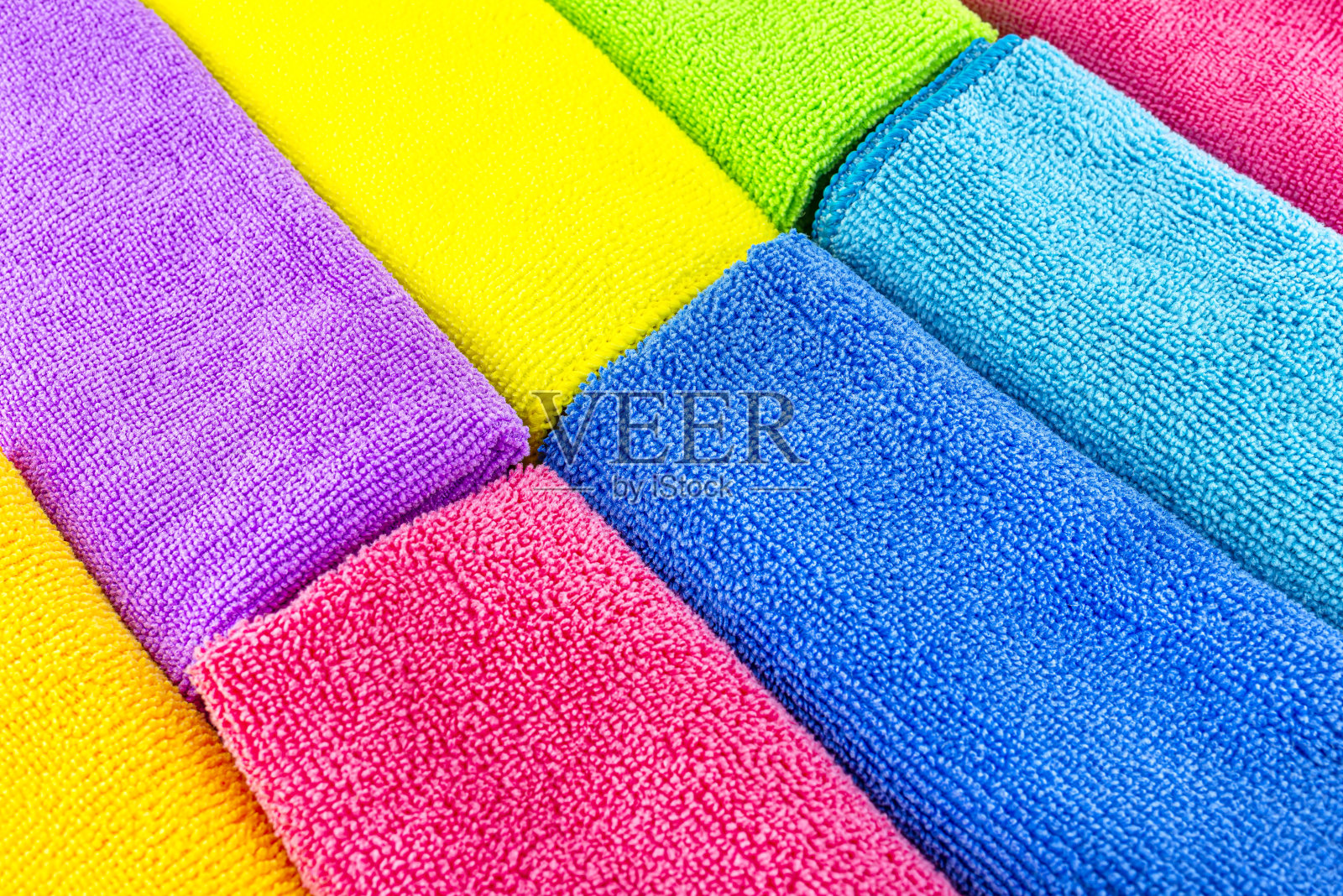 背景由不同颜色的超细纤维材料并排堆叠而成，俯视图。照片摄影图片