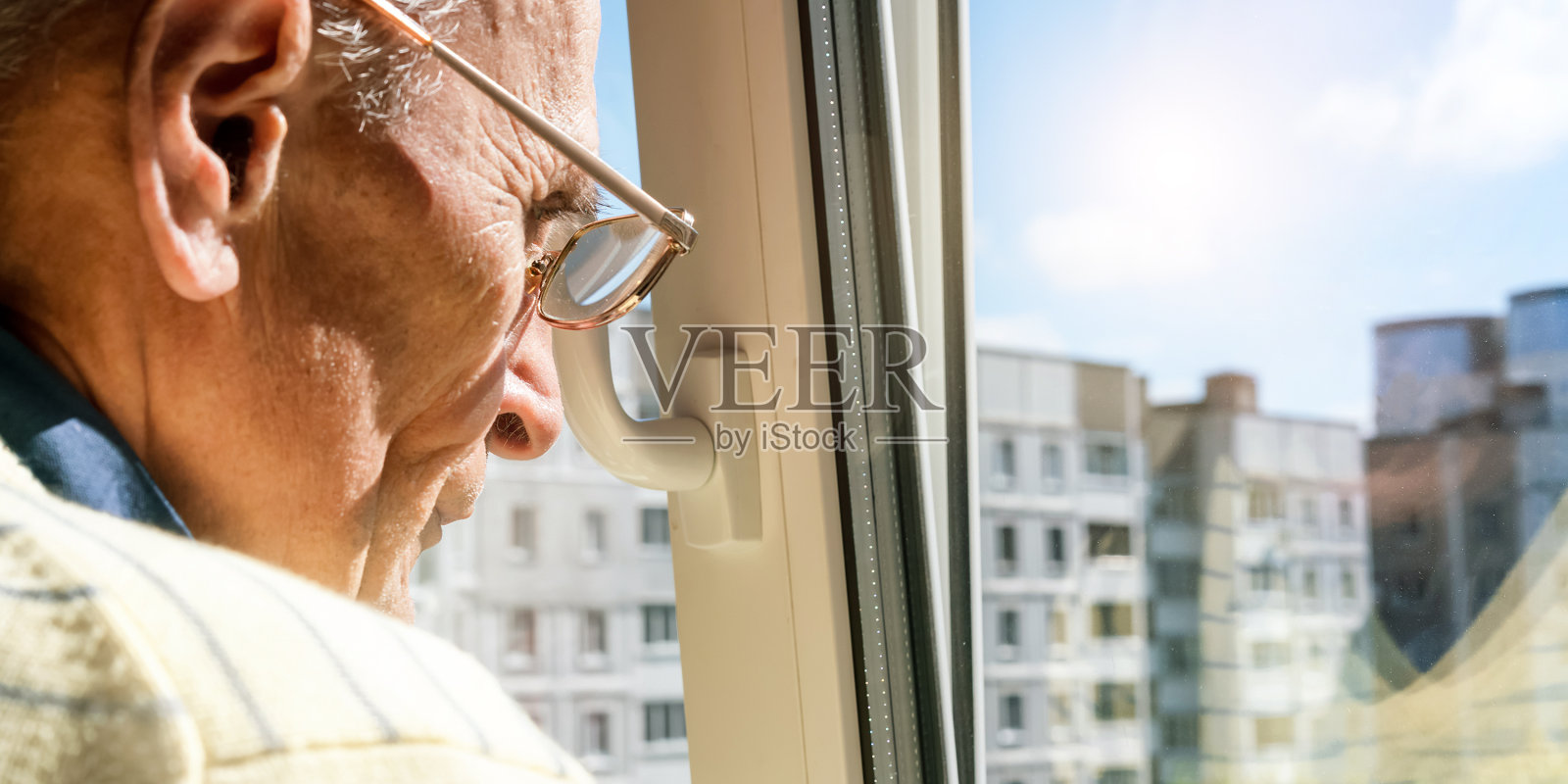 一位老人站在窗前欣赏当地的城市风景照片摄影图片