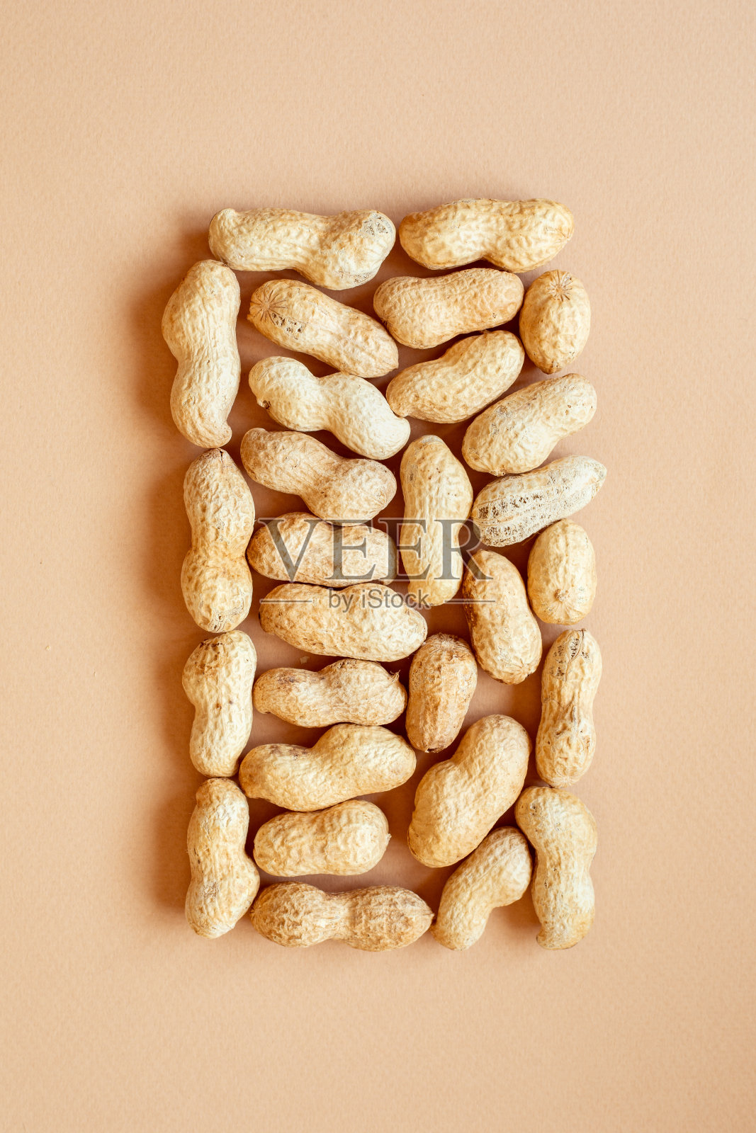 米色背景上的核桃纹理。花生壳中照片摄影图片