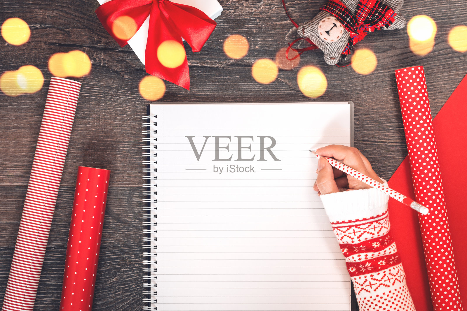 手与记事本圣诞树和红色礼物包装纸照片摄影图片