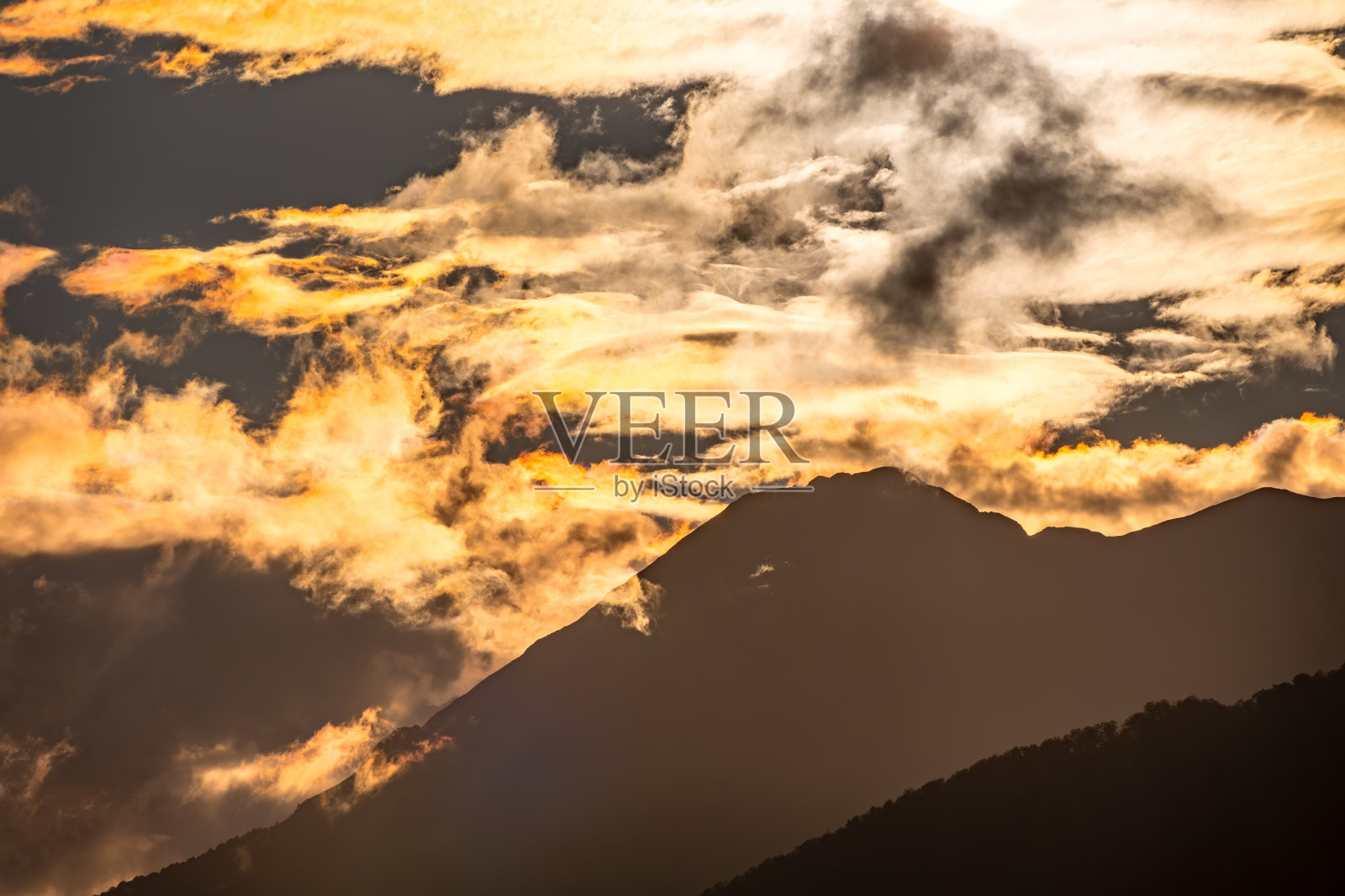 橘色多云日落的山脉剪影照片摄影图片