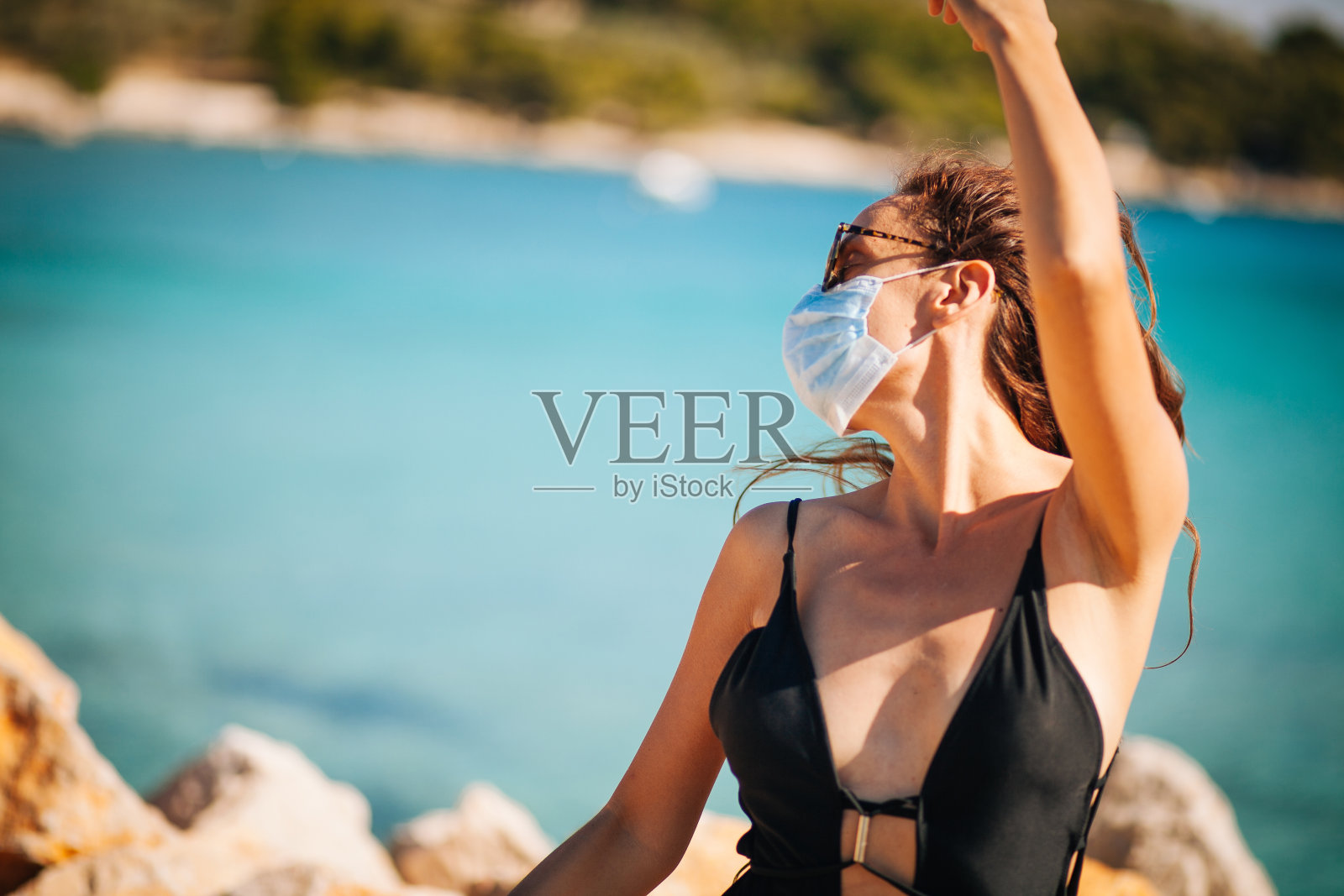 性感的女人在海滩上休息与保护面具照片摄影图片