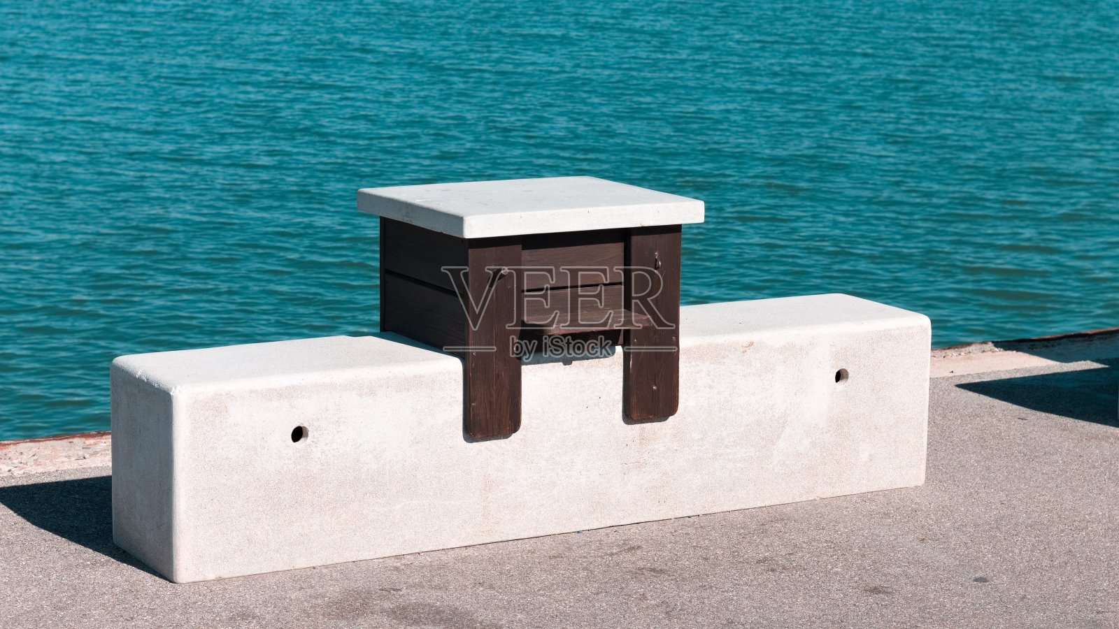 港口码头上的一张孤零零的木桌和大理石座椅(意大利，Pesaro，欧洲)照片摄影图片