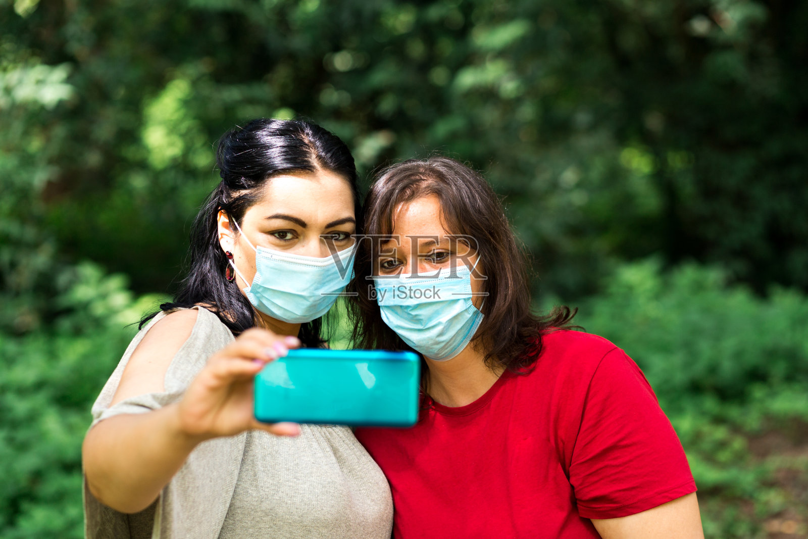 朋友们戴着防护口罩在公园里自拍照片摄影图片
