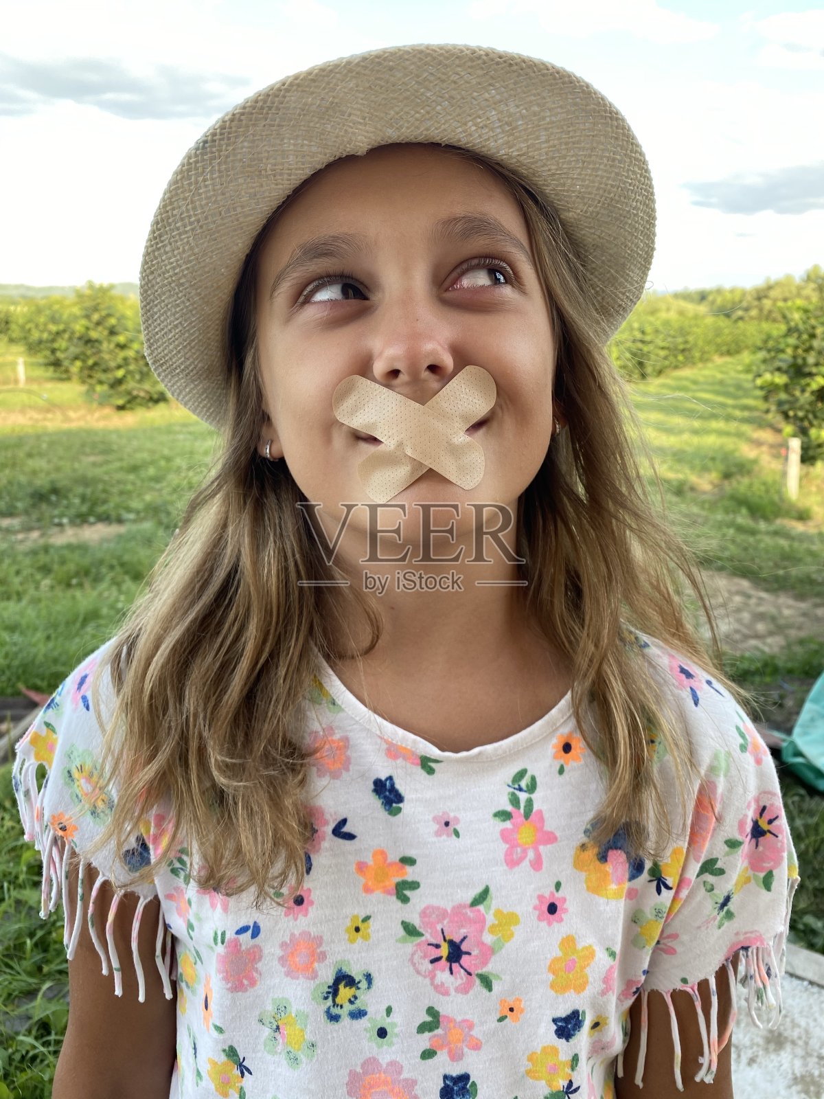 可爱的9岁女孩微笑着贴在她的嘴照片摄影图片