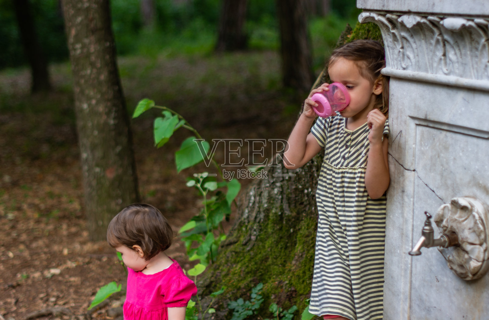 儿童饮用公共喷泉的水照片摄影图片