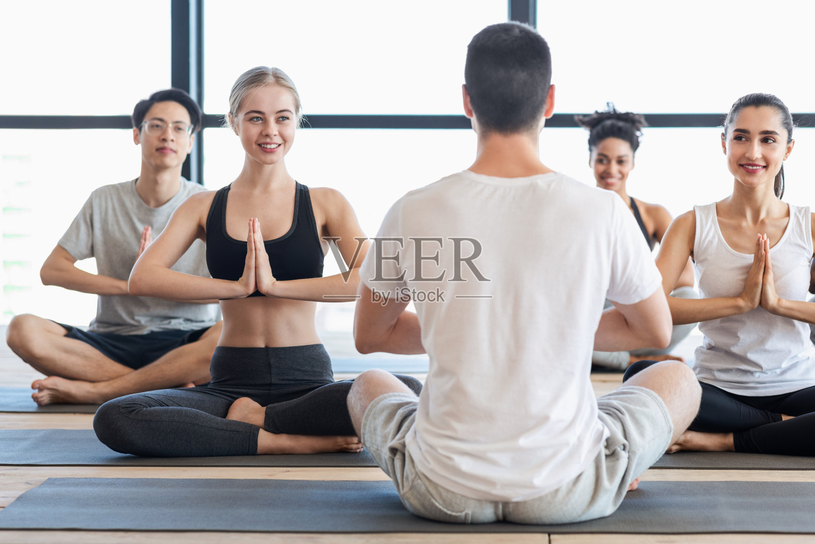 瑜伽教练。一群年轻人与教练练习冥想练习照片摄影图片