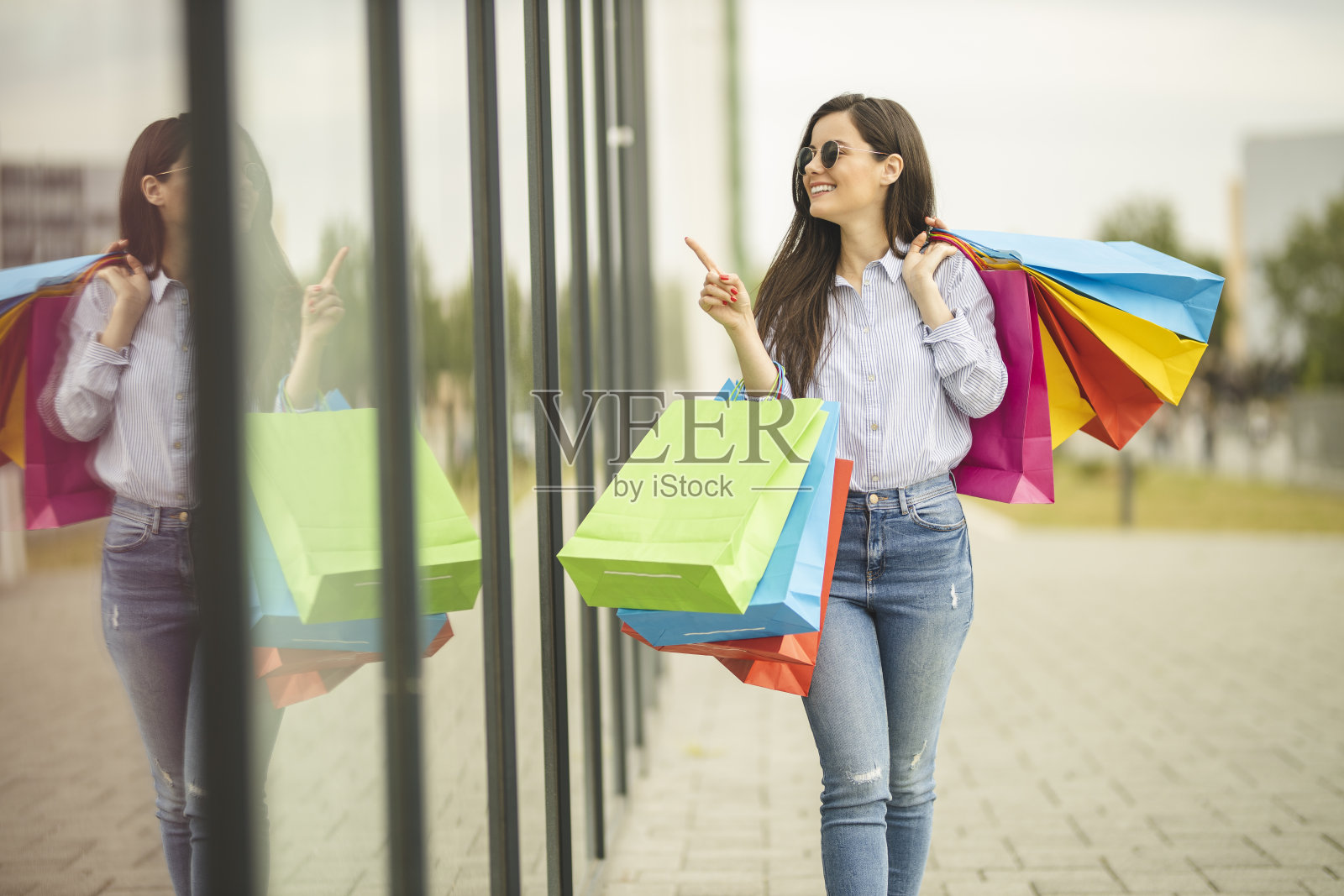 快乐的女人拿着购物袋在购物中心享受购物照片摄影图片