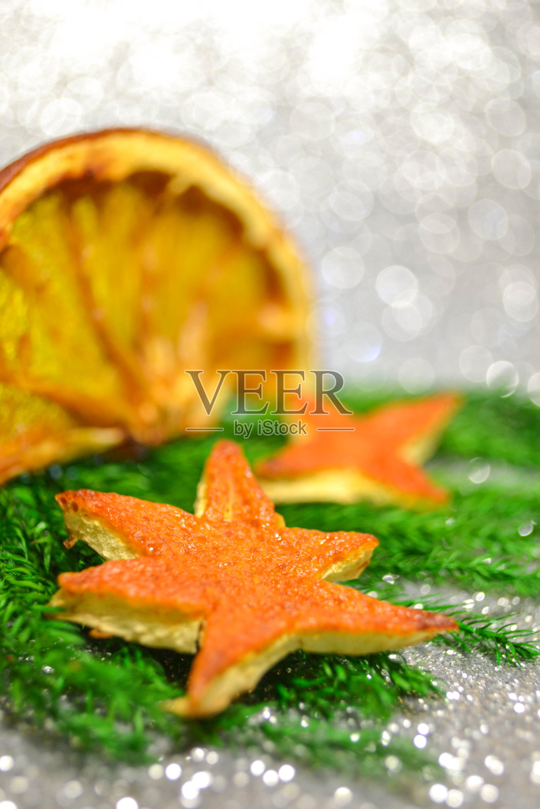 干橘子片手工装饰，圣诞树上模糊的白色散糕。假日宏社交媒体概念与复制空间照片摄影图片