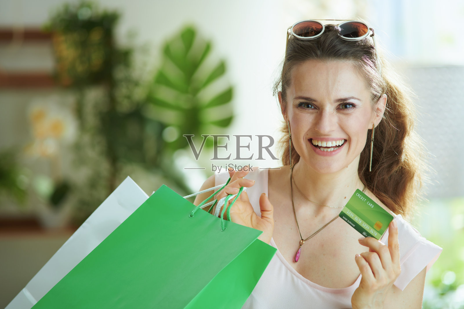 微笑的现代女性购物者的肖像在衬衫与包照片摄影图片