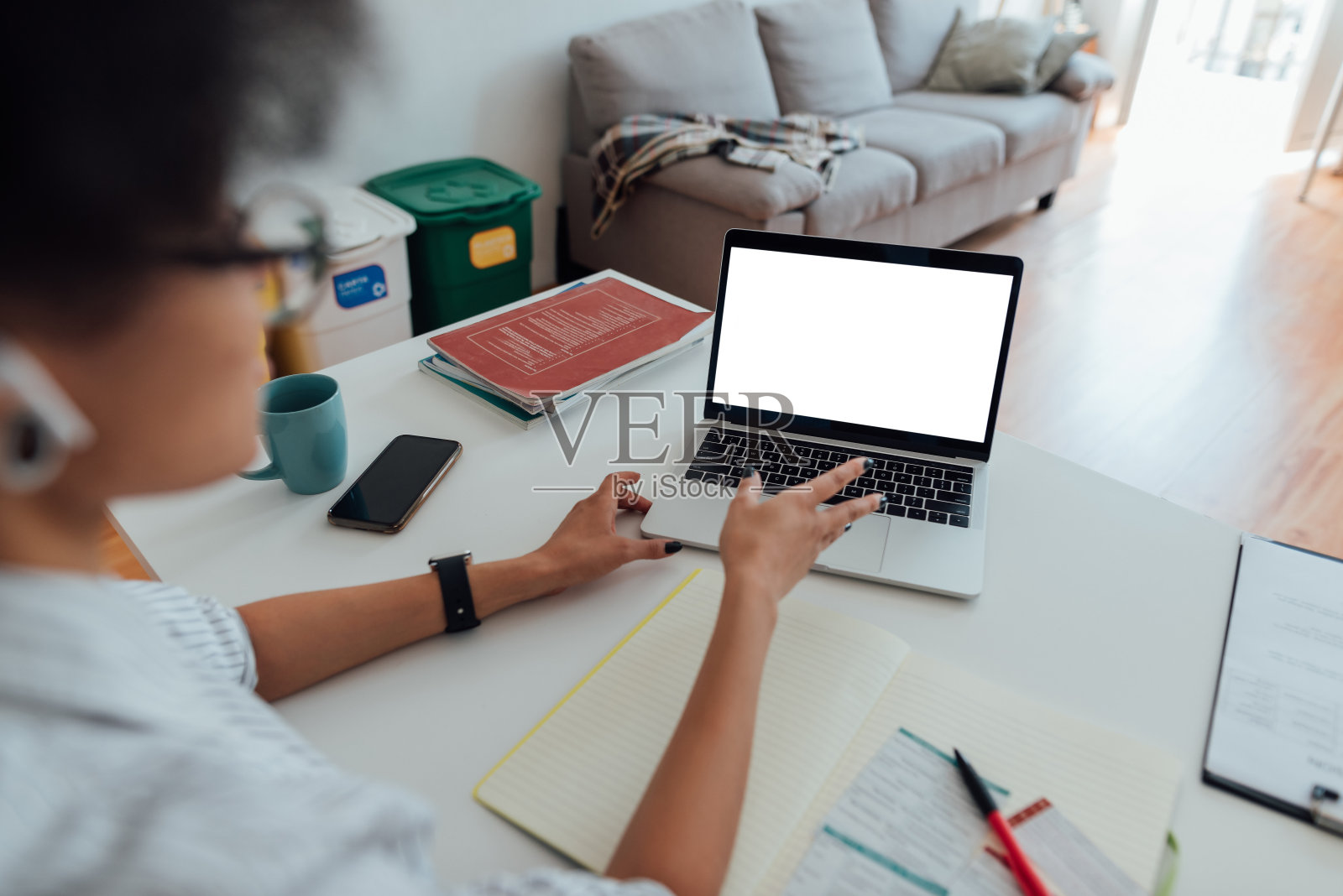 后视图的非洲裔美国妇女戴着无线耳机看着网络摄像头和教英语，而从家里工作照片摄影图片