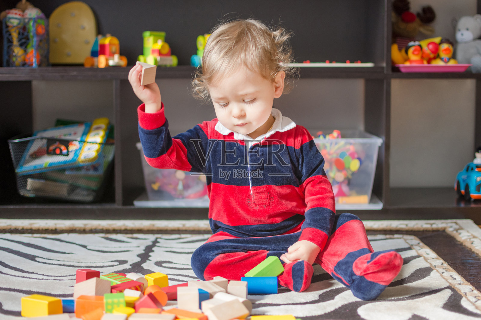 可爱的小男孩在家里玩五颜六色的积木，在地板上玩。照片摄影图片