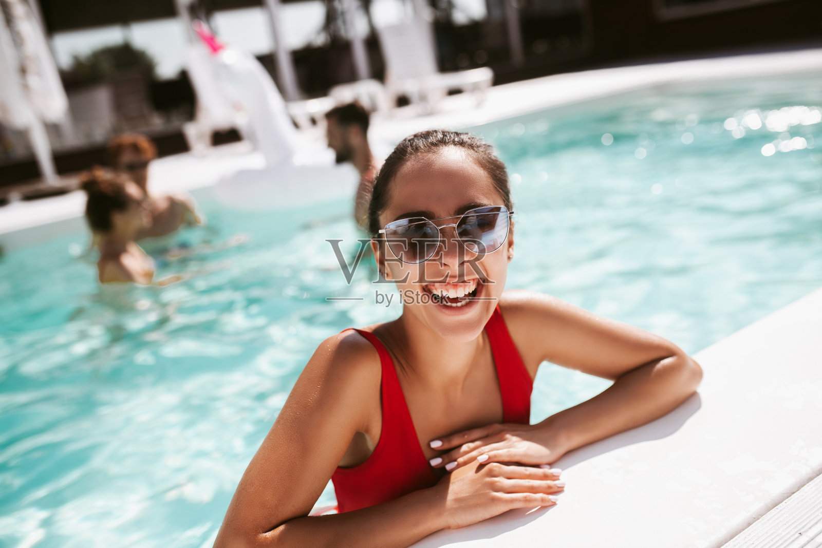 微笑年轻漂亮的女人在红色泳衣感觉棒极了照片摄影图片