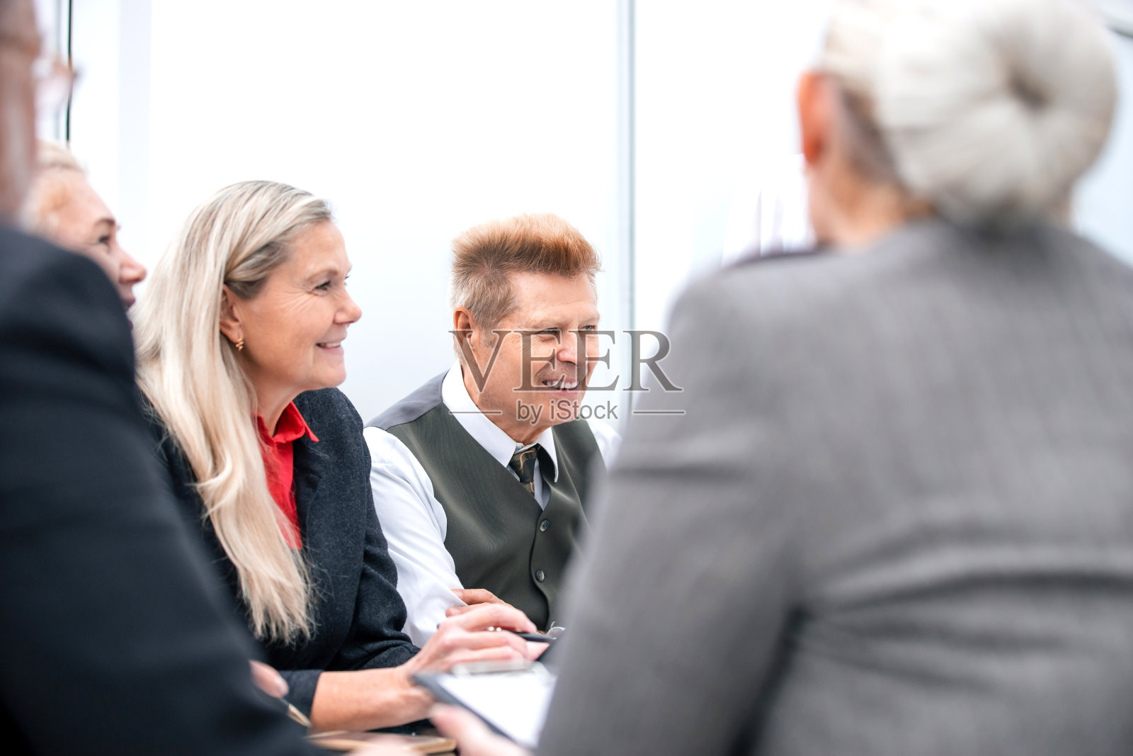 笑容可掬的商人在工作会议上与同事交谈照片摄影图片