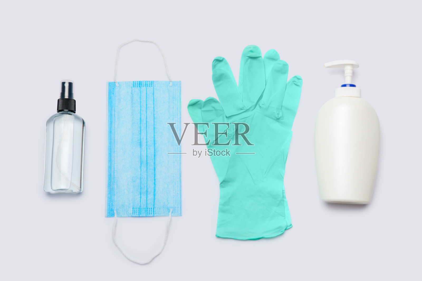 卫生用品平面布局-乳胶手套，口罩和洗手液在浅灰色背景照片摄影图片