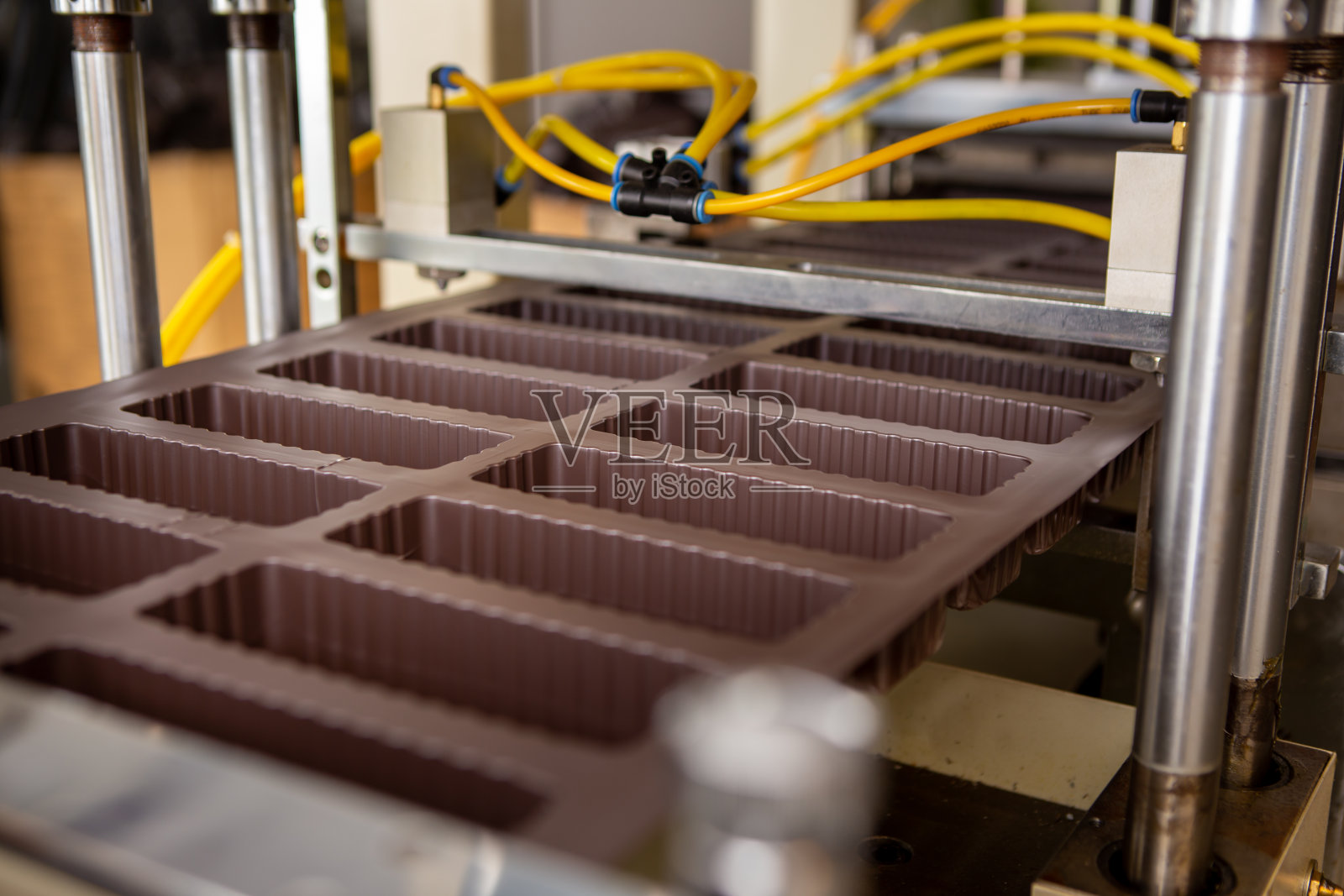 专注于新制作的塑料盒子。这些盒子是刚从塑料模压机上出来的。照片摄影图片