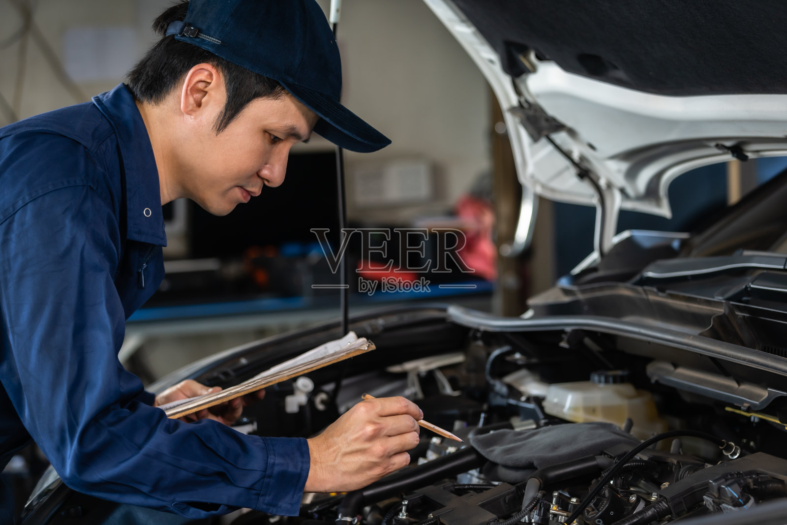 男机械师检查和修理服务车与剪贴板照片摄影图片