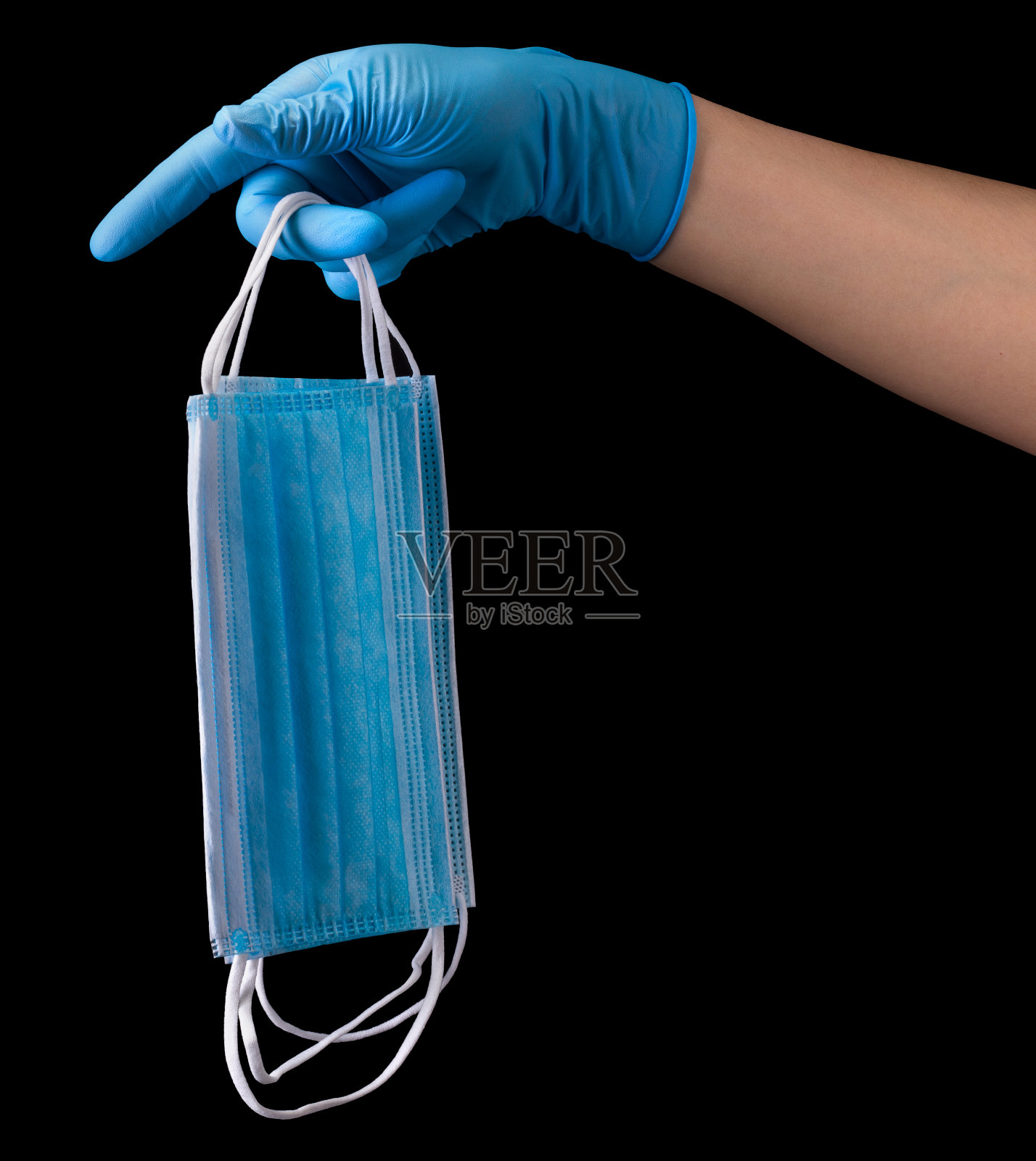 医生的手上拿着医用手套，一堆口罩隔离在黑色照片摄影图片