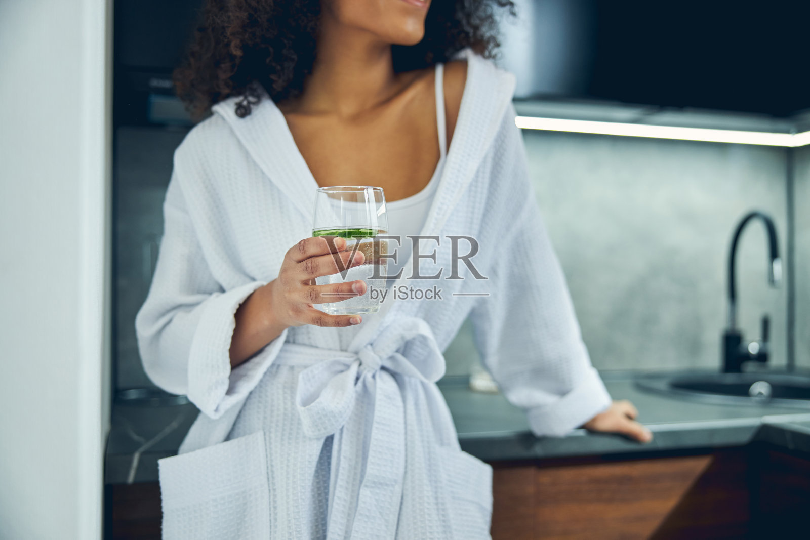 苗条的女人拿着一杯黄瓜饮料照片摄影图片