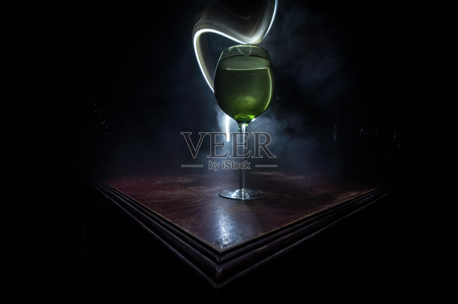 木墙背景上的木桌上放着一杯白葡萄酒照片摄影图片