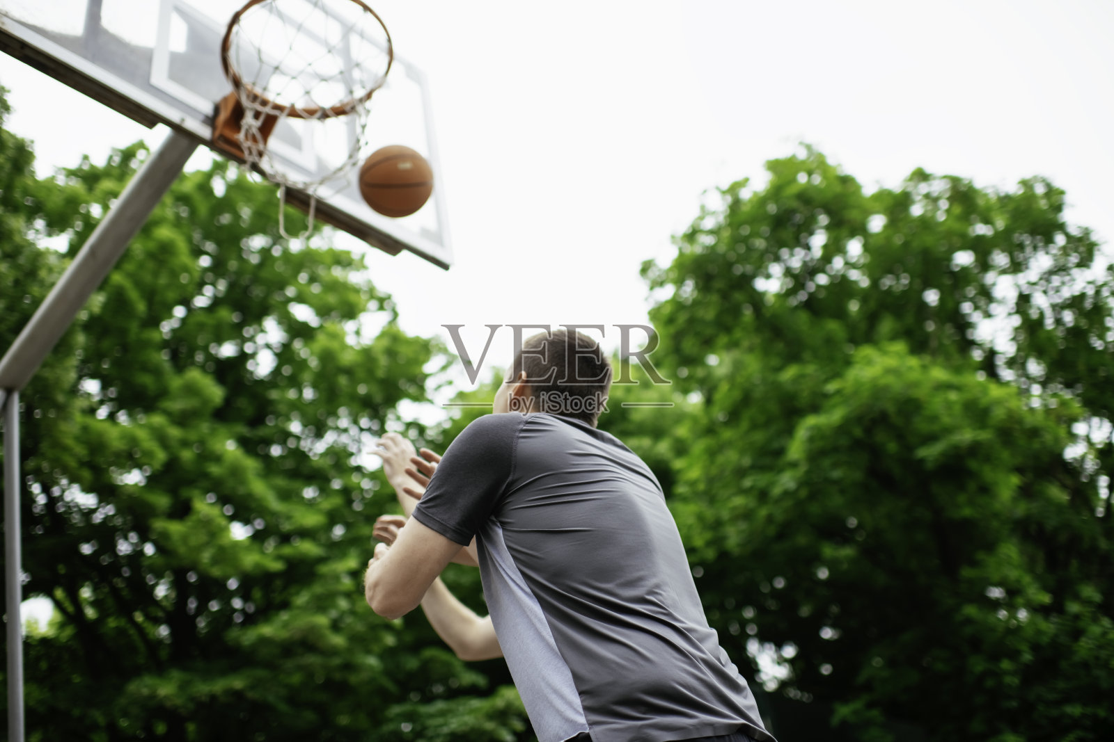 两个朋友在户外打篮球，玩得很开心。照片摄影图片