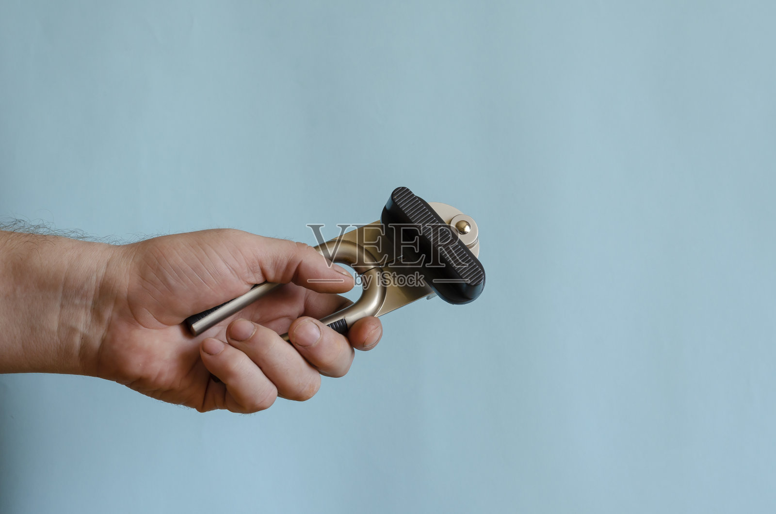 男人的手握着一把罐头钥匙。照片摄影图片