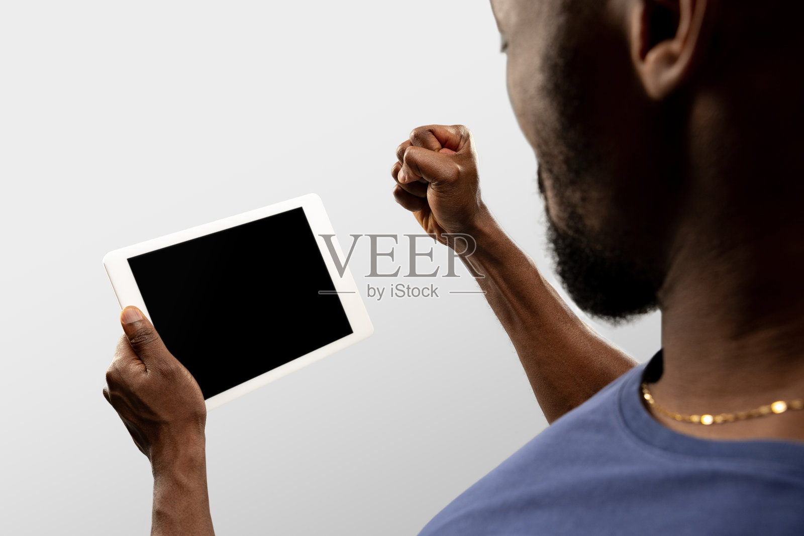 在网上观看世界各地流行的体育比赛和锦标赛时，男性手握平板电脑，屏幕为空白。Copyspace广告照片摄影图片