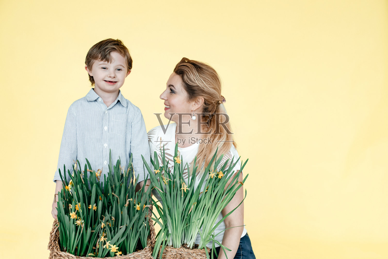 妈妈和宝宝在纯黄色背景上照片摄影图片