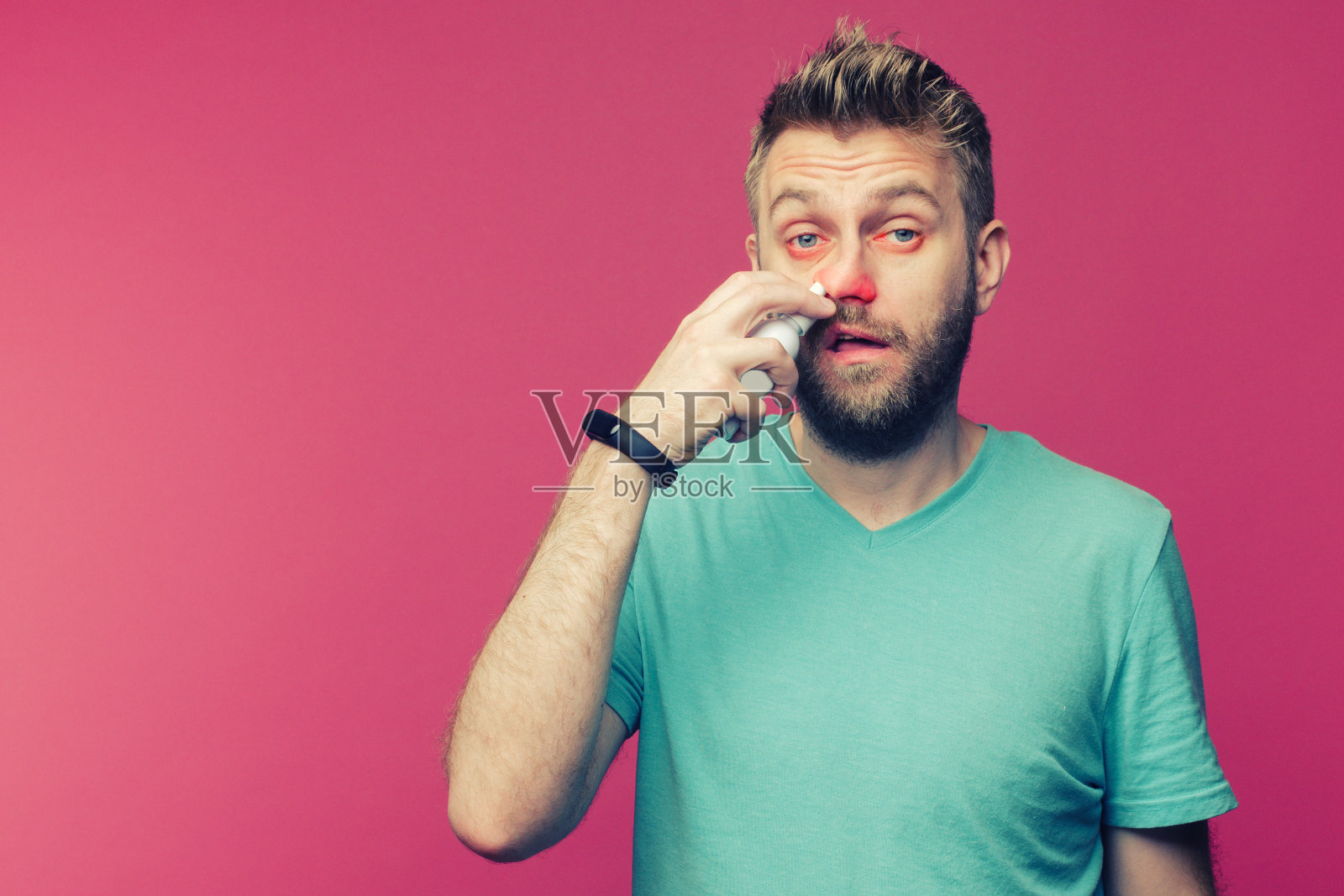 一名年轻男子用鼻喷剂拍摄的照片。被隔离的病人流鼻涕。人类研制出了治疗普通感冒的药照片摄影图片