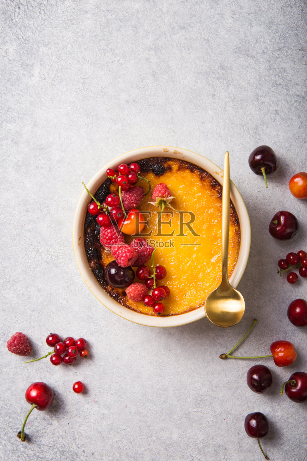 烤盘上有覆盆子的焦糖布丁。为你的标题留出空间。照片摄影图片