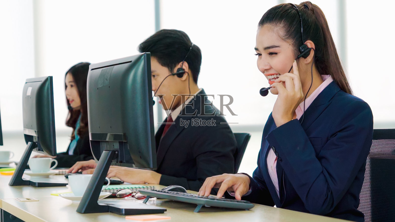 商务人员戴着耳机在办公室工作照片摄影图片