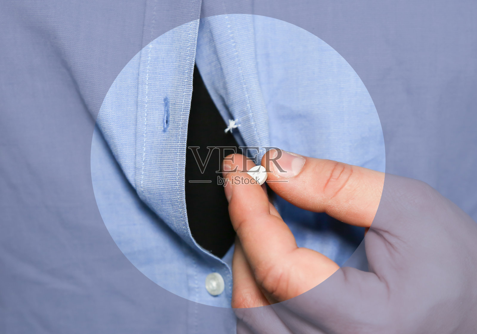 把衬衫。男人握着松开的按钮。衣服需要修补和缝纫。照片摄影图片