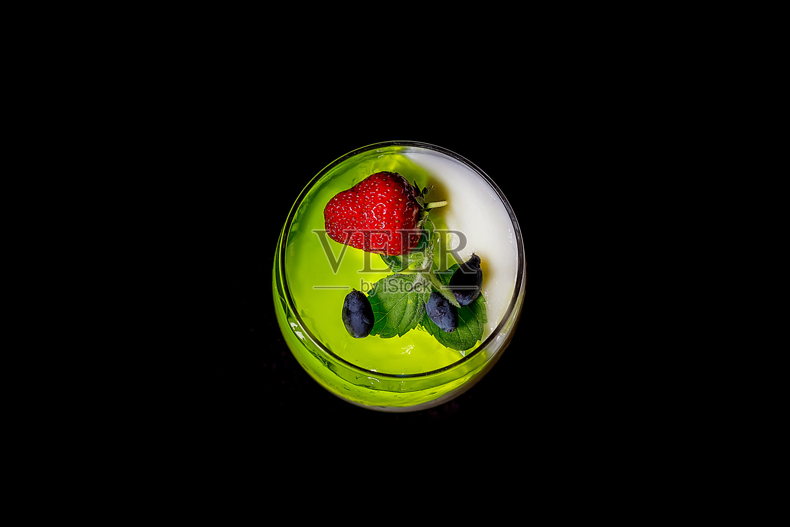 自制酸奶配绿莓果冻或玻璃杯酸奶配新鲜草莓、金银花和薄荷叶。关闭了。黑暗的背景。照片摄影图片