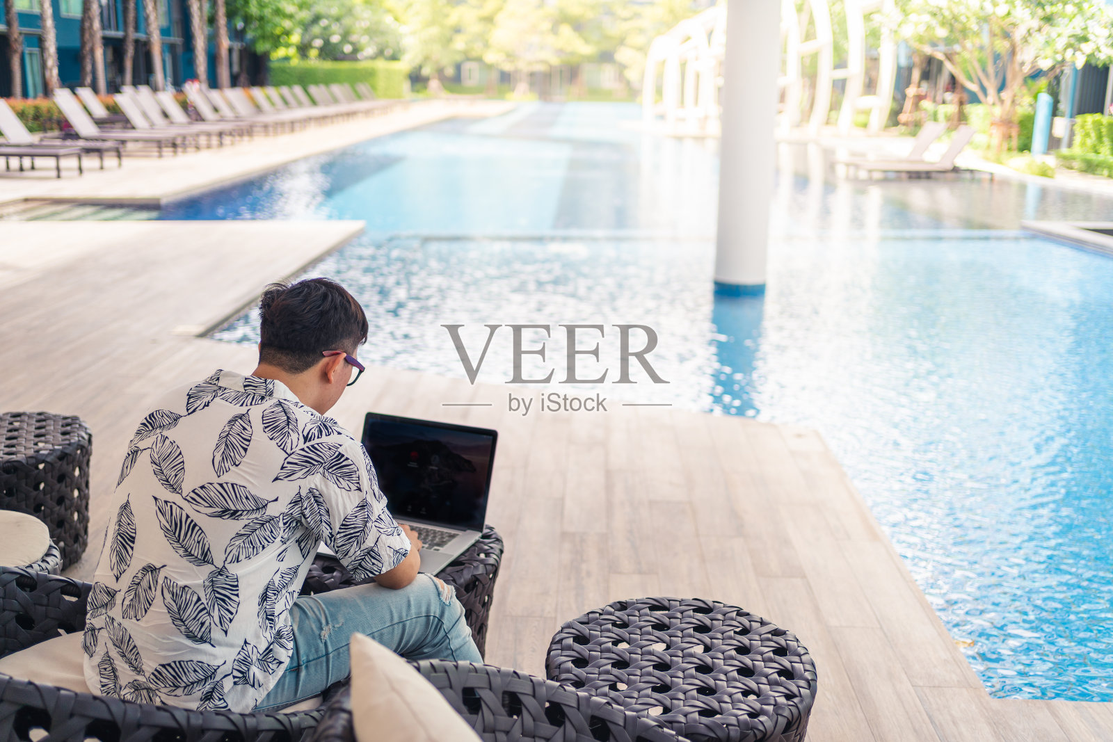 年轻的亚洲人用笔记本电脑工作。与冠状病毒或Covid-19疫情保持社交距离。社会距离概念照片摄影图片