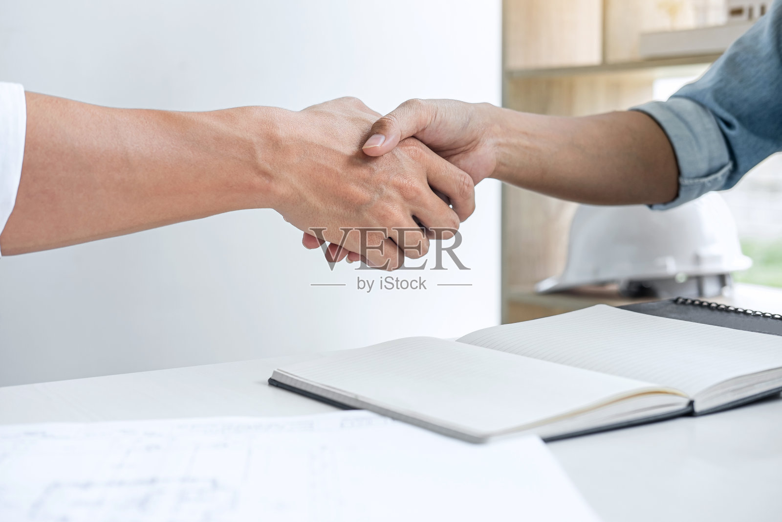 2 .会议和问候，两位工程师或建筑师就项目进行会议，协商后握手，会议新的项目计划，为双方签订合同，成功，合作照片摄影图片