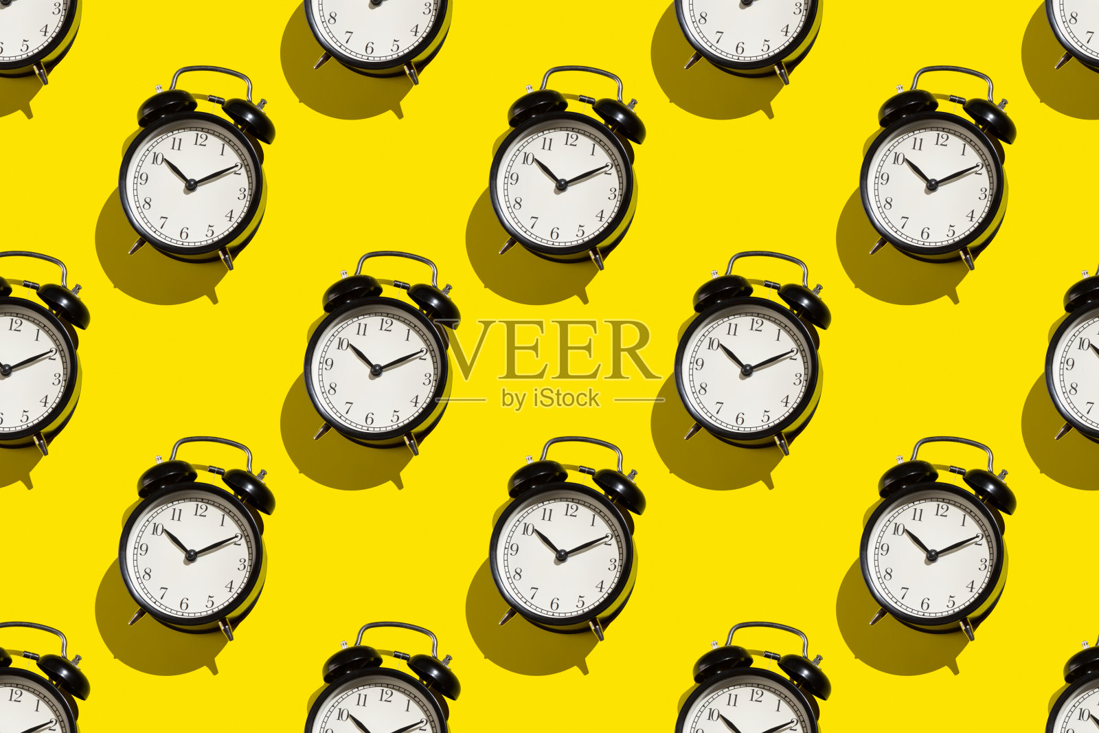 黄色背景上的老式闹钟。抽象的图案照片摄影图片