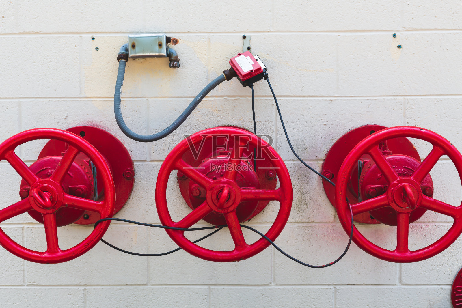 关闭混凝土墙上的工业用水阀门照片摄影图片