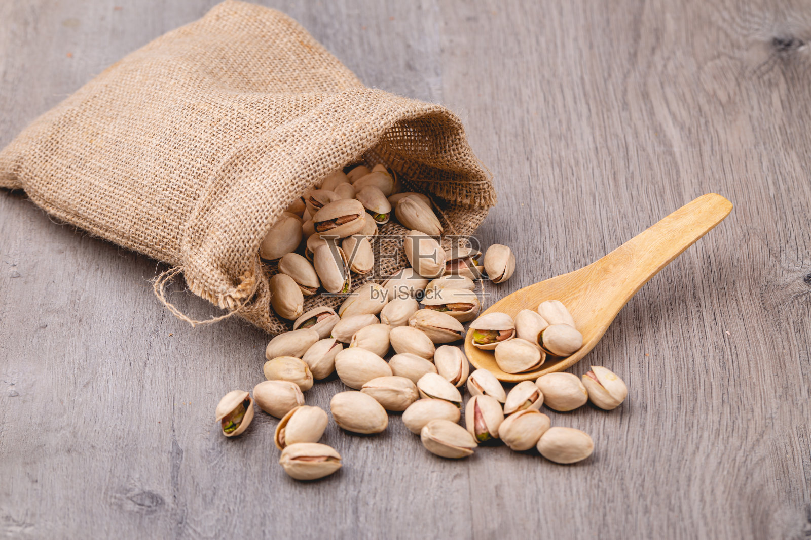 把开心果装在袋子里放在木桌上照片摄影图片