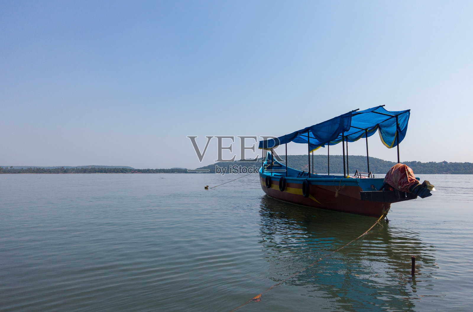 海上五颜六色的游船。明亮的游船和船上的人漂浮在平静的海水上，与无云的蓝天在阳光明媚的一天在度假村照片摄影图片