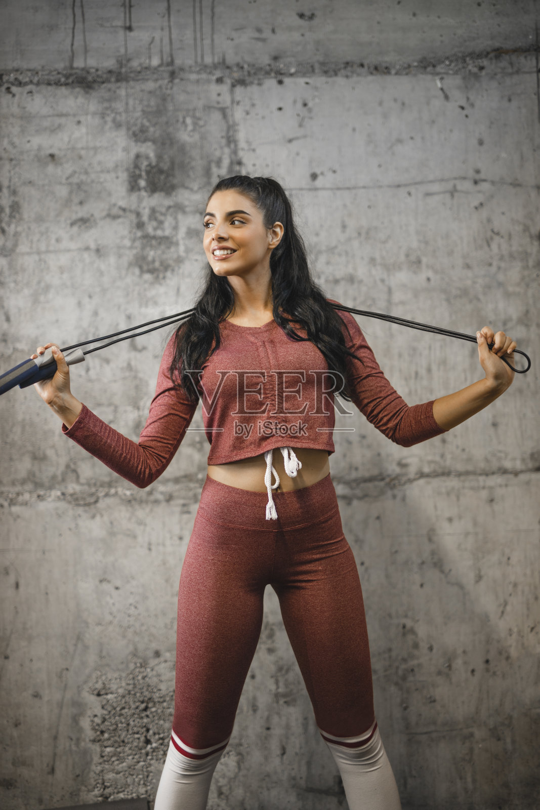 美丽的健身女子与跳绳穿着运动服和锻炼照片摄影图片
