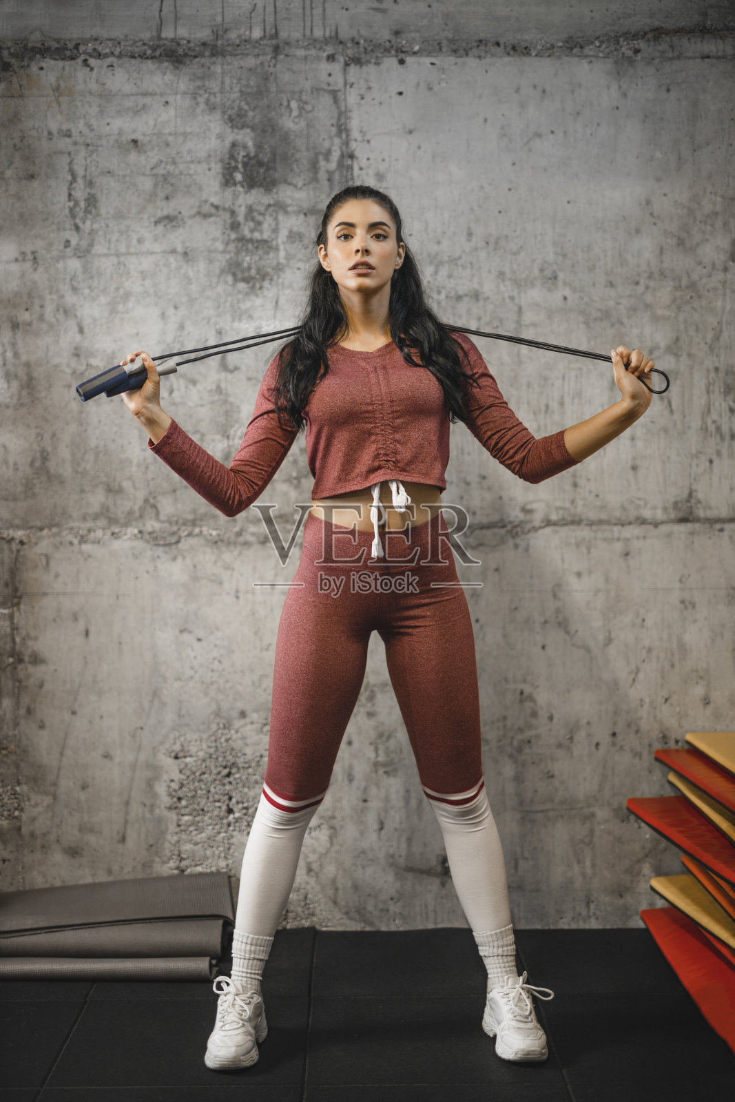 认真美丽的健身女人穿着跳绳运动服和锻炼照片摄影图片