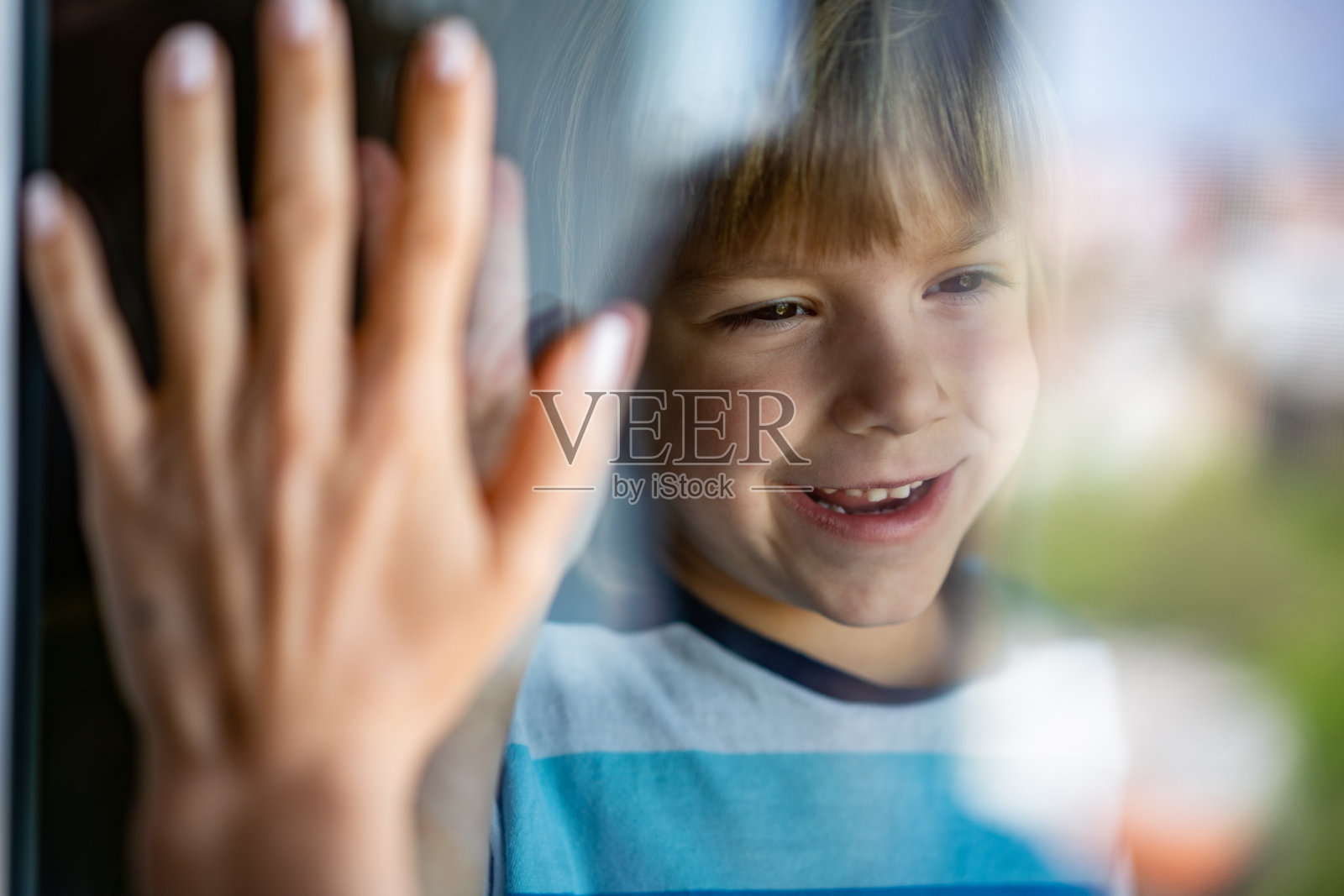 小男孩在窗户后面微笑照片摄影图片