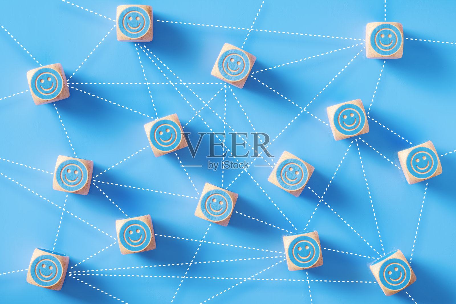笑脸符号绘制的蓝色木头块由虚线连接坐在蓝色的背景照片摄影图片