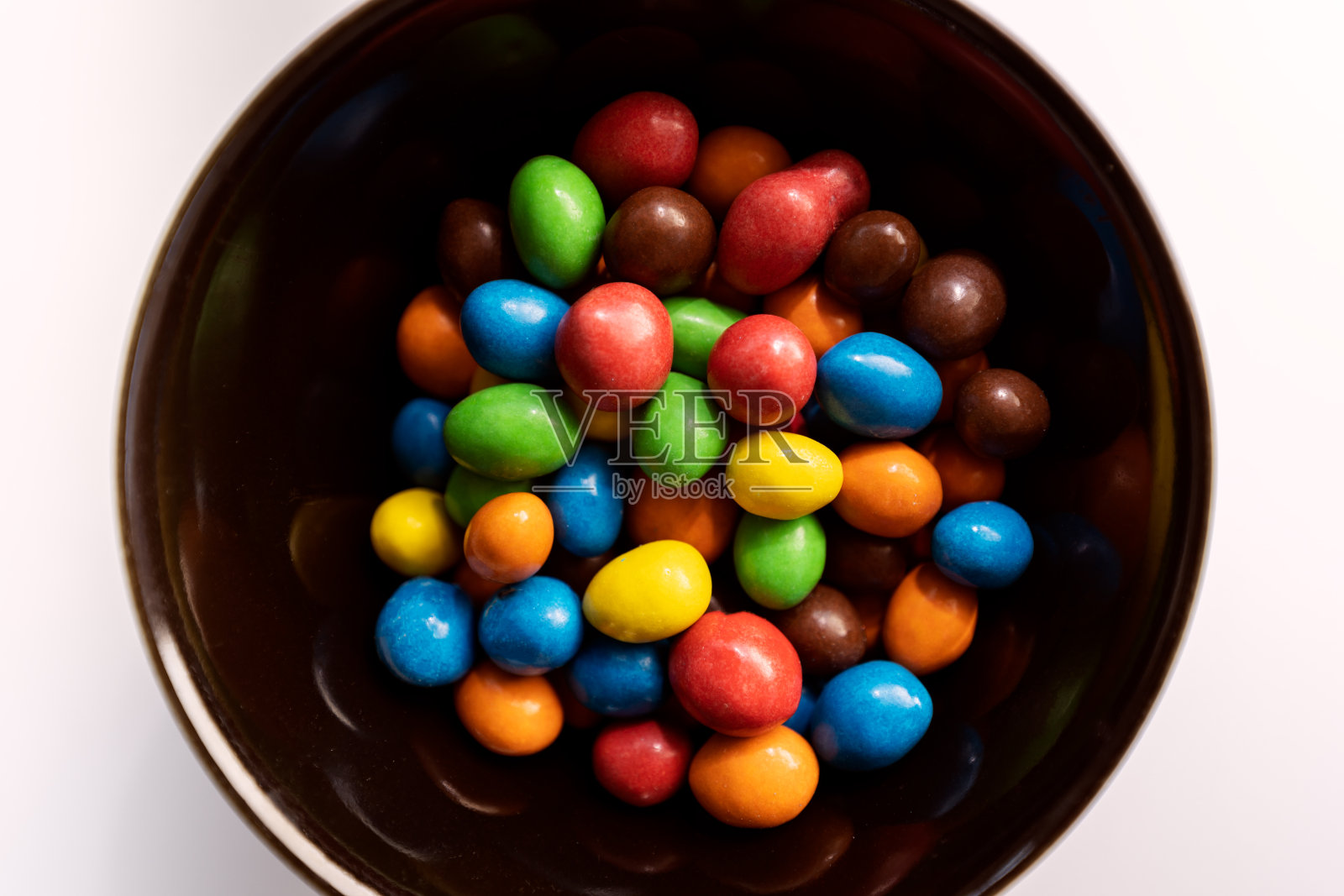 黑色的碗里装着五颜六色的糖果照片摄影图片