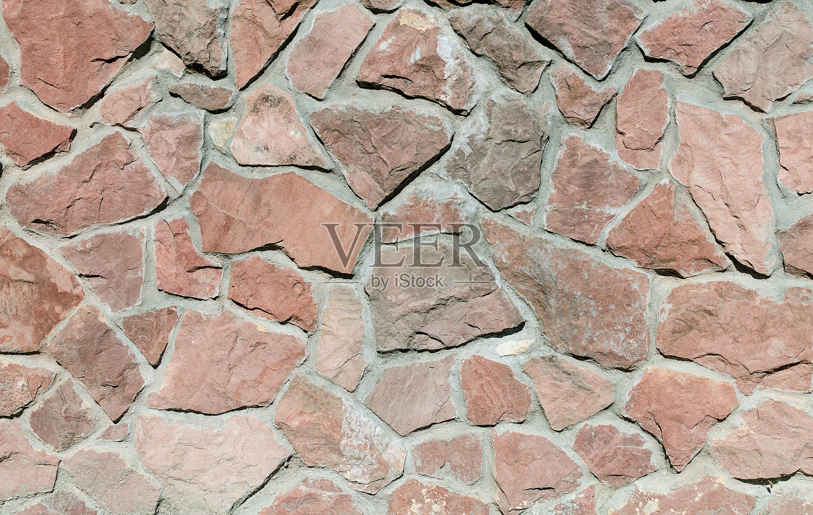 有纹理的砖石栅栏，栅栏用亮棕色的石子照片摄影图片