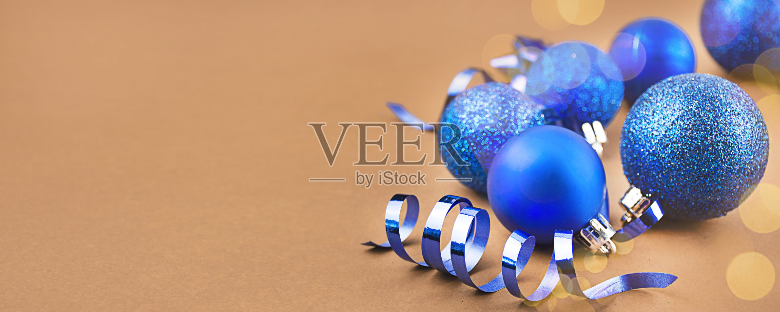 圣诞贺卡从蓝球在一个棕色的背景与高光。圣诞假期作文。横幅模型,明信片。特写镜头。副本的空间。照片摄影图片