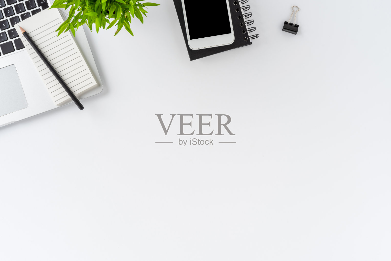 头顶拍摄的现代办公桌面与笔记本电脑和业务配件在白色背景与copyspace。平躺照片摄影图片